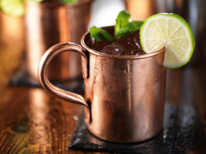 moscow mule cocktail on wooden table close up